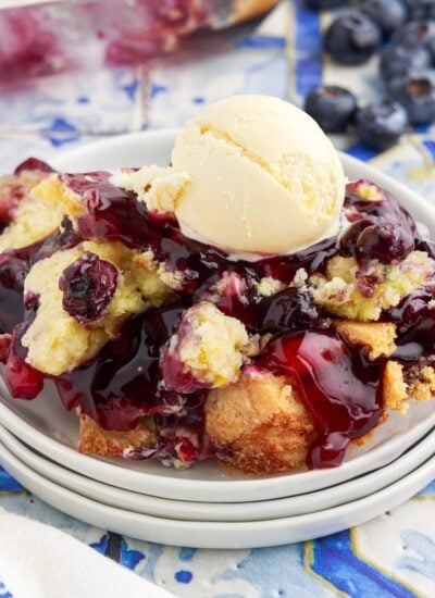 Close up of a serving of Blueberry Dump Cake with a scoop of vanilla ice cream.