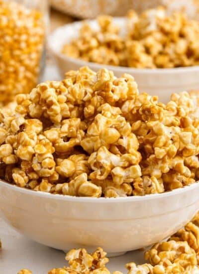 Bowls mounded with caramel corn and a jar of corn kernels in background.