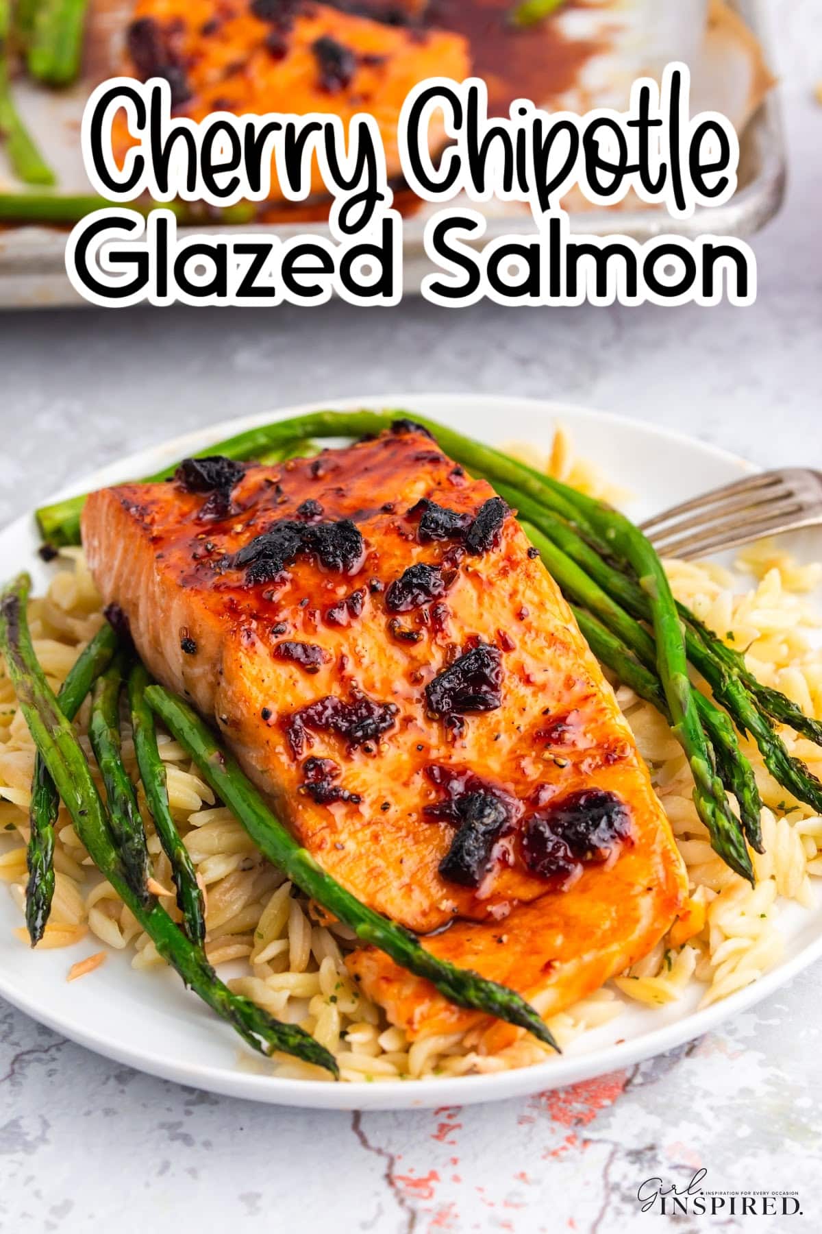 Filet of cherry chipotle glazed salmon plated with roasted asparagus and rice pilaf.