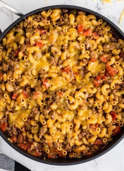 Cooked Chili Mac in skillet, topped with melted cheese.