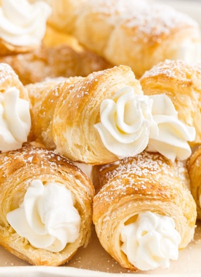 Cream Horns stacked on each other on a plate.