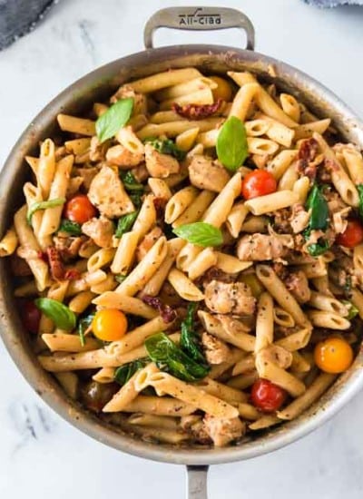 creamy chicken pasta in saucepan with grey dishtowel