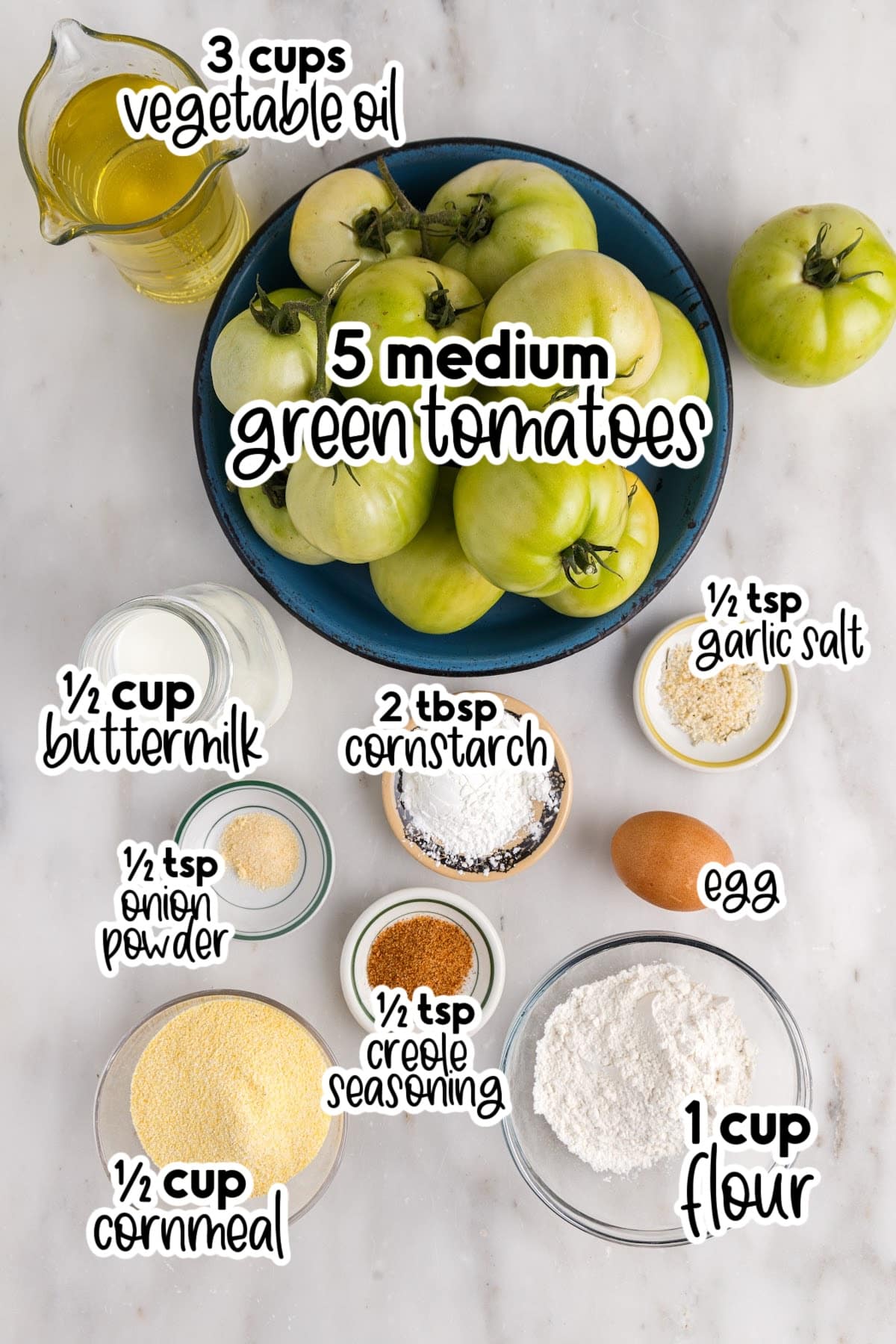 Ingredients to make fried green tomatoes on the counter in various sized bowls and text overlays.