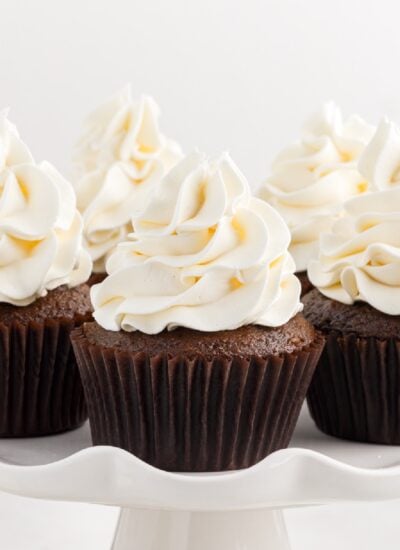 Close up of a cake platter full of cupcakes topped with Marshmallow Cream Frosting.