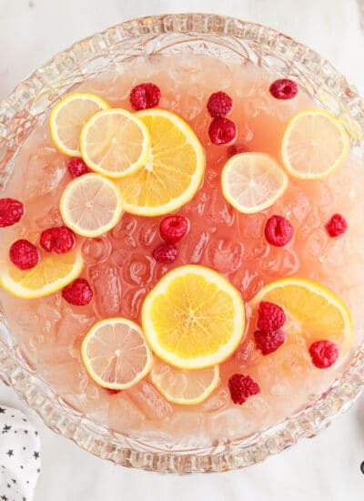 Top view of Party Punch Recipe showing the sliced lemons and berries inside the punch with other ingredients in the background.
