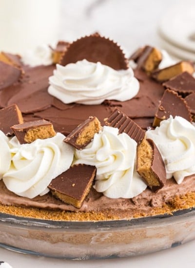 Glass pie dish filled with Peanut Butter Chocolate Ice Cream Pie on marble counter top