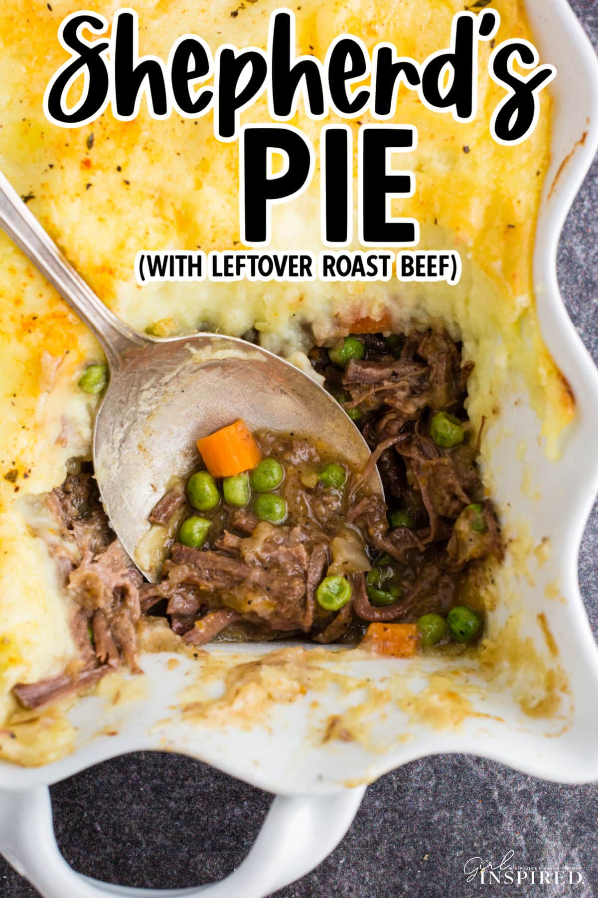 Overhead view of baked shepherd's pie with leftover roast beef in a casserole dish with a serving removed and a silver serving spoon resting in the pie.