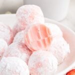 A stack of Strawberry Truffles with one on top with a bite out of it.