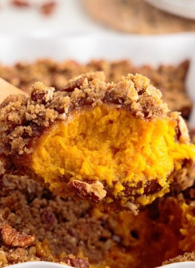 Front close up of a scoop of Sweet Potato Souffle on a wooden spoon.