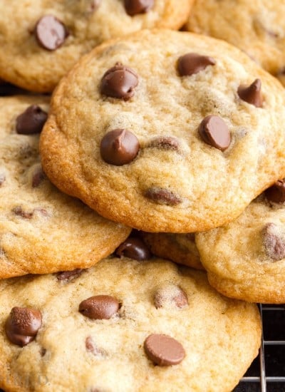 Front close up of Toll House Chocolate Chip Cookies stacked on a cooling rack.